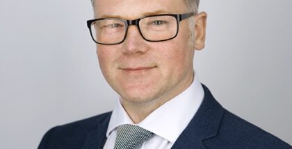 Headshot of Robert Thompson (a caucasian man wearing glasses and dressed in a suit with tie)