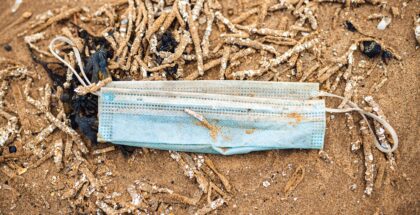 Image shows a soiled disposable mask lying on ground