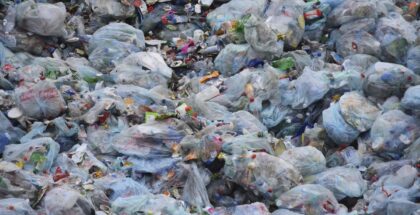 Image shows a large pile of garbage in bags